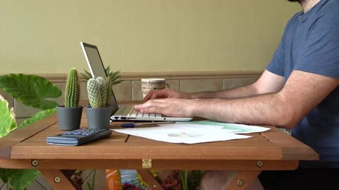 Young man sitting at table typing on a laptop during work remotely from home Stock Footage 162560972