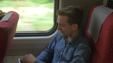 Young man sitting on the train while using mobile phone Stock Footage 51832722