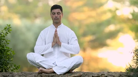 Young Man sitting on the wall and meditating Stock Footage 56809494
