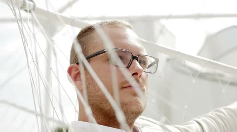 Young man sitting in white swing relaxing outdoors. thinking bout life Stock Footage 64800820