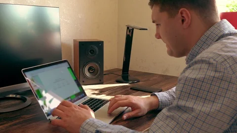 Young man sitting working on a laptop computer Stock Footage 125896375