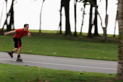 Young man skating through park Stock Photos