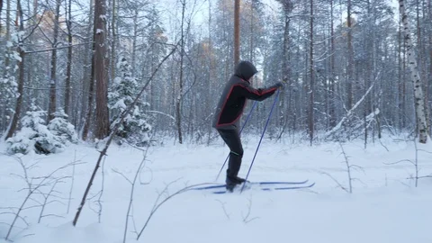 A young man is skiing in the winter forest. Stockbeeldmateriaal 124514196