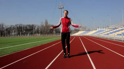 Young man skipping jumping working out training outide at big stadium sunny day Stock Footage 137542253