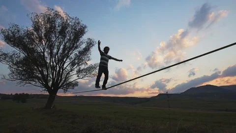 Young man slack lining in beautiful natural  scenery Stock Footage 121868511