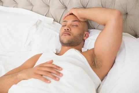 Young man sleeping in bed Stock Photos