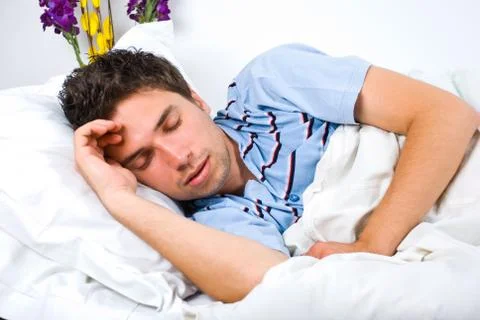 Young man sleeping in bed Fotos Stock