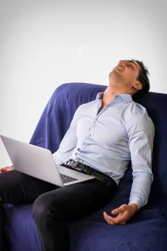 Young man sleeping with computer on couch Stock Photos