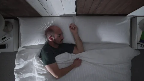 Young man sleeping deeply in her bed at nigth Stock Footage 71362412