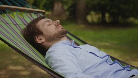 A young man is sleeping on a hammock Stock Footage 128841597