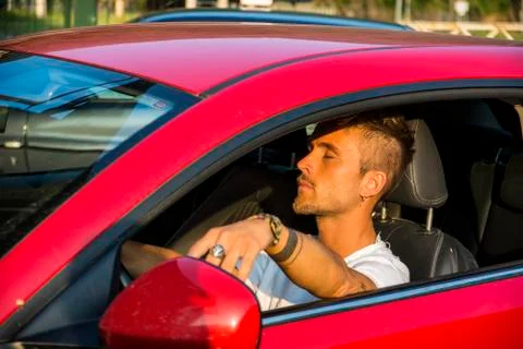 Young man sleeping inside his car, exhausted Stock Photos