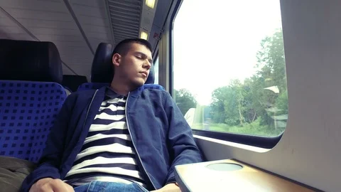 Young man is sleeping on the train on a long journey on the way home home Stock-Footage 106596458