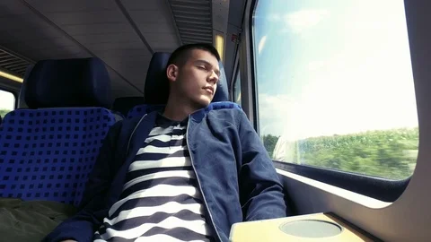 Young man sleeping while traveling with a train Stock Footage 106595748