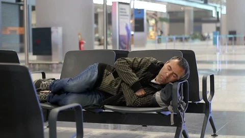 Young man sleeping while waiting the plane at airport passenger terminal Vídeos de archivo 98321486