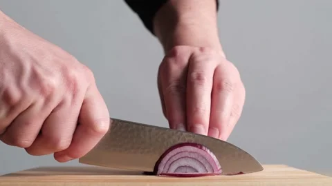 Young man slicing up half a red onion. Stock Footage 133809458