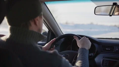 The young man slowly driving a car on a winter road. Stock Footage
