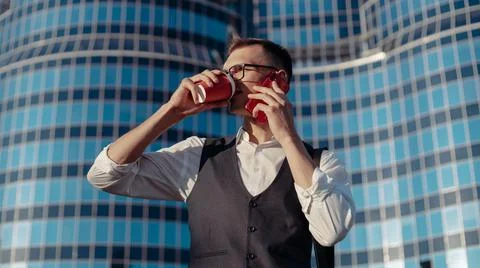 Young man with a smartphone on the background of a large office building . Stock Photos