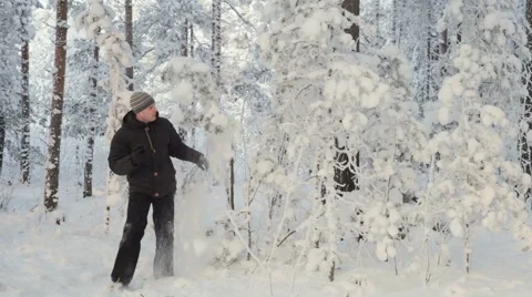 Young man with smartphone looking for direction in winter snowy forest Video stock 59771886
