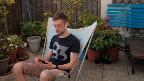 Young man with the smartphone meditates using meditation app on terrasse 库存影片 111514806