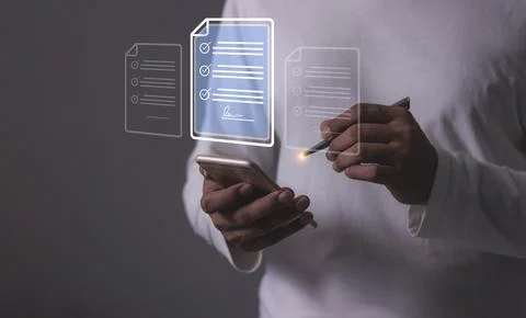 Young man with smartphone mobile hand using a pen touching to sign a Online.. 库存照片