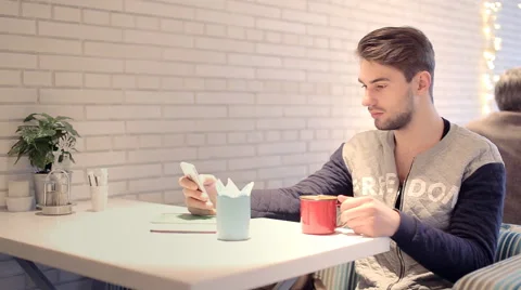 Young man with smartphone sitting in cafe Stock Footage 63067032