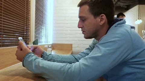 Young man with smartphone sitting in cafe Stock-Footage 81161073