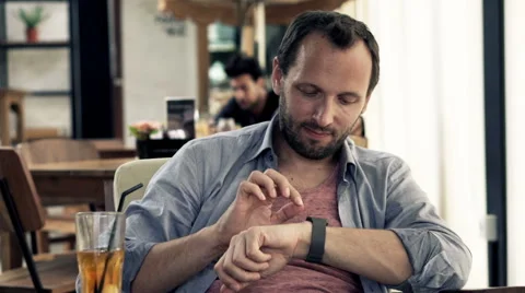 Young man with smartwatch drinking juice in cafe HD Stock Footage 51877950