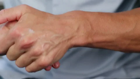 Young man smearing a white moisturizer on his hands close-up. Morning routine Stock Footage 257090346