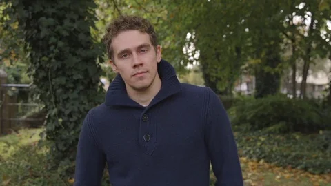 Young man smiles at the camera with confidence in a park Stock-Footage 72681839