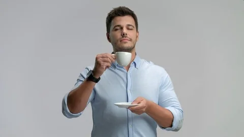 Young man smiling and drinking from a cup Vidéo 77950877