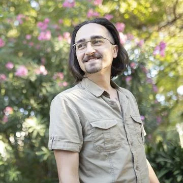 Young man smiling and looking away in a blooming garden Stock Photos