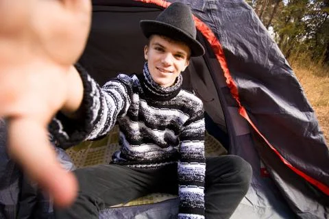 Young man smiling and taking selfie in forest camp from smart phone. Traveler Stock Photos