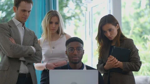 Young Man smiling at camera as pan towards fraud laptop group concerned Stock Footage 89921831