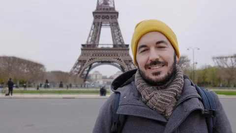 Young man smiling at camera standing over Eiffel Tower in Paris Video stock 258751326