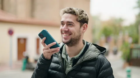 Young man smiling confident talking on the smartphone at street Stock Footage 171382443