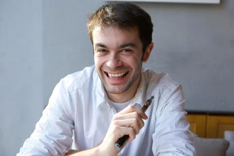 Young man smiling with e cigarette Stock Photos