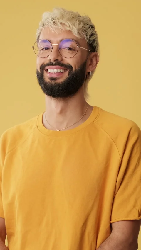 Young man smiling looking at camera isolated on yellow background in studio Stock Footage 253935265