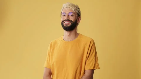 Young man smiling looking at camera isolated on yellow background in studio Stock Footage 255964406