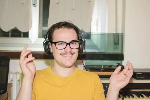 Young man smiling moving hands while listening music with headphones Stock Photos