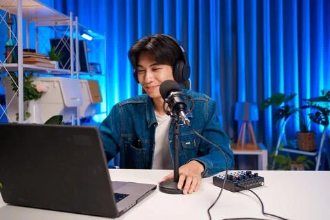 Young man smiling while hosting podcast session Stock Photos