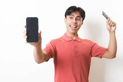 Young man smiling while showing a smartphone and holding a credit card, ill.. Stock Photos