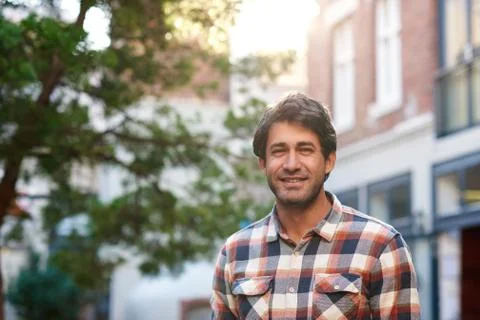Young man smiling while standing on a city street Stock Photos