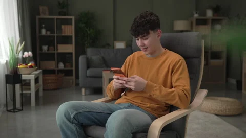 Young man smiling while texting on smart phone Video stock 328362027