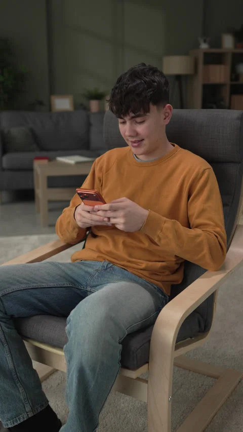 Young man smiling while texting on smart phone Stock Footage 328362355