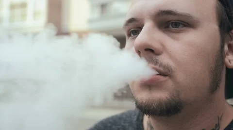 Young Man Smoke E-Cigarette On The Street. Vape. Slow-Mo. Video stock 65039613