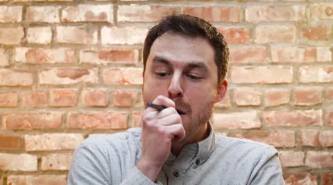 A young man smokes an e cigarette indoors Stock Footage 62812361