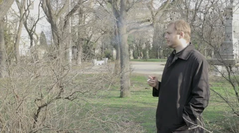 Young man smokes at a park Vidéo 59856819