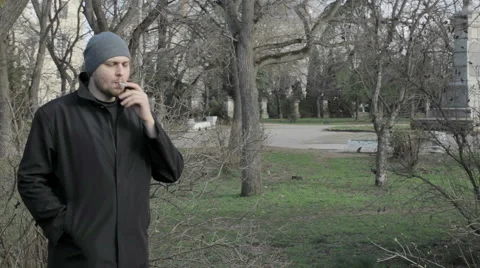 Young man smokes at a park Vidéo 59856868