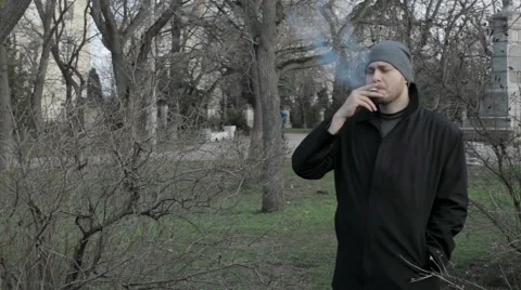 Young man smokes at a park Vidéo 59856881