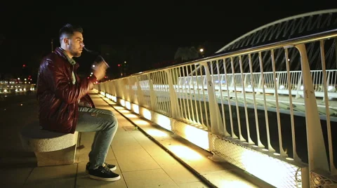 Young man smoking cigarette on a bridge at the night Stock Footage 61097938